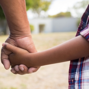 Cropped image of boy and grandfather holding hands while standing in yard l'accueil durable et bénévole
